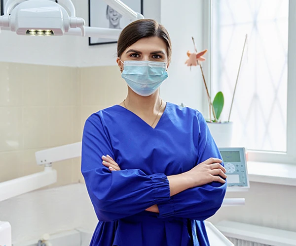 Dental clinic worker stood with her arms crossed